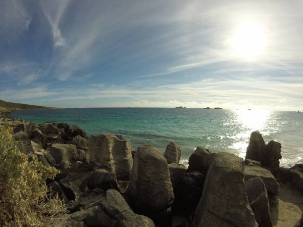 istock Granite shore line with a setting sun over the ocean 1251512663