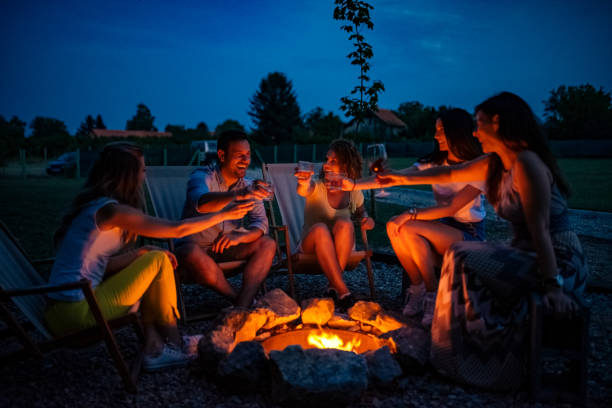 istock Friends enjoying evening drinks by firepit outdoors. 1251514236