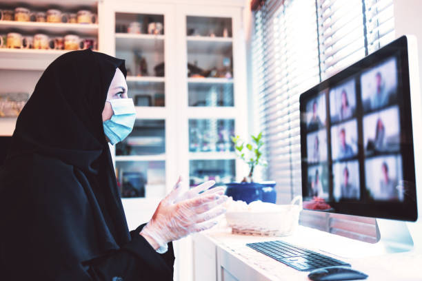 arabska kobieta uczestniczy w rozmowie wideo podczas pracy z domu - covid-19 series - dubai house built structure middle east zdjęcia i obrazy z banku zdjęć