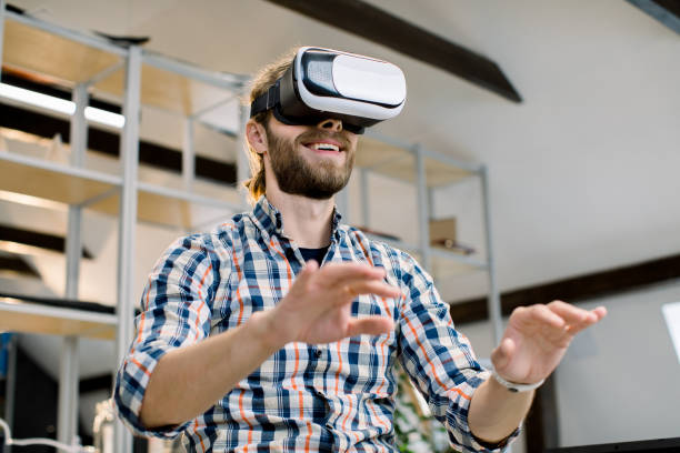 istock Business, technology, augmented and virtual reality concept. Cheerful Caucasian hipster bearded business man having the VR experience and adjusting the headset 1251519388