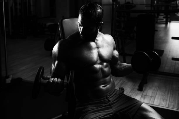 istock Muscular Man Training Biceps With Dumbbells 1251520183