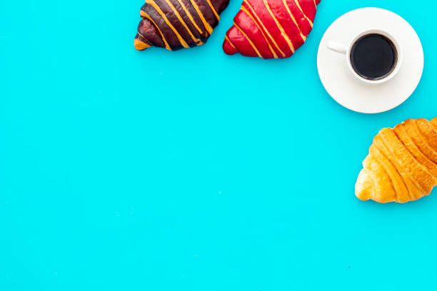 Croissants with coffee - breakfast on blue stone table top view.