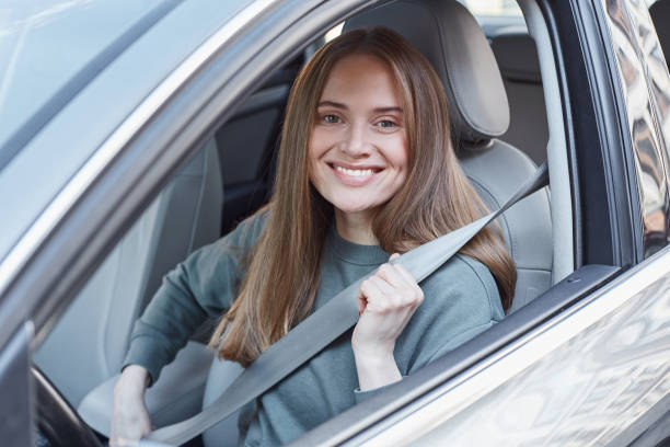 istock Charming young woman sitting at car wheel 1251522681