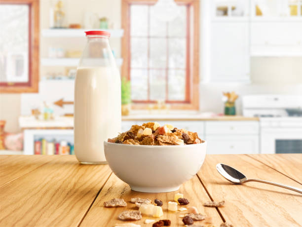 bouteille de lait et croustillant fruité sur la table de la cuisine. - céréales du petit d�éjeuner photos et images de collection