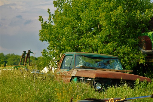 A beautiful old classic car wasting away in a field