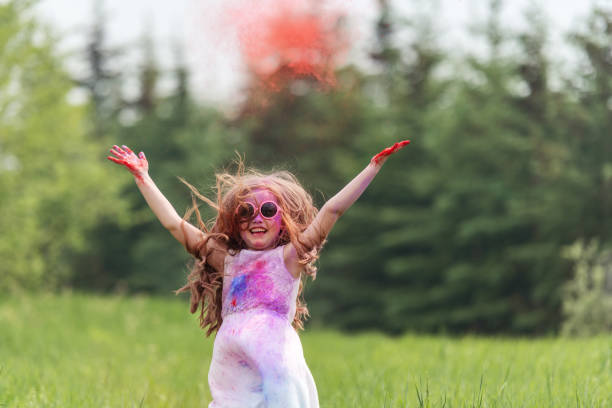 Brother and sister in backyard playing with colored powder, Quebec, Canada