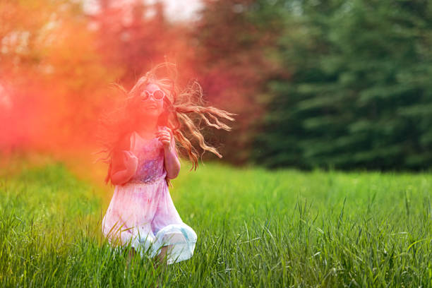 Brother and sister in backyard playing with colored powder, Quebec, Canada