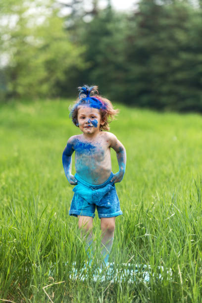 istock Brother and sister in backyard, playing with colored powder 1251525772