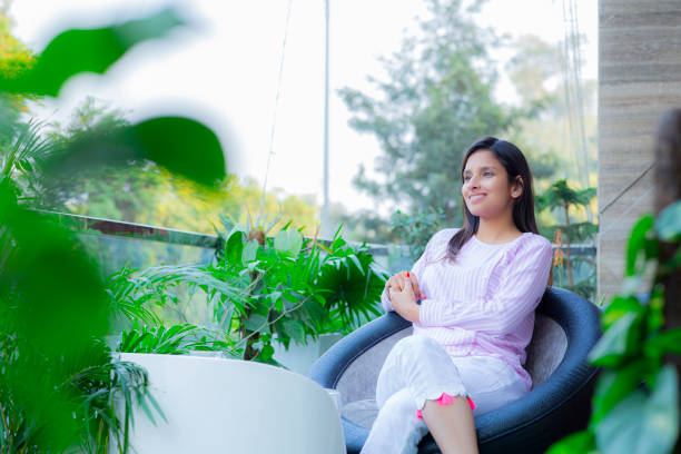 young woman - stock images Indian, Indian ethnicity, lifestyle, Modern, Adult, Young woman woman sitting cross legged in chair stock pictures, royalty-free photos & images