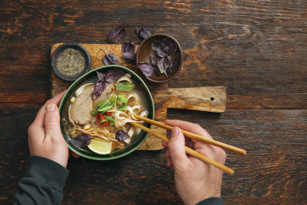 Adult Man Eating Authentic Pho Beef Noodle Soup. Vietnamese Traditional Food