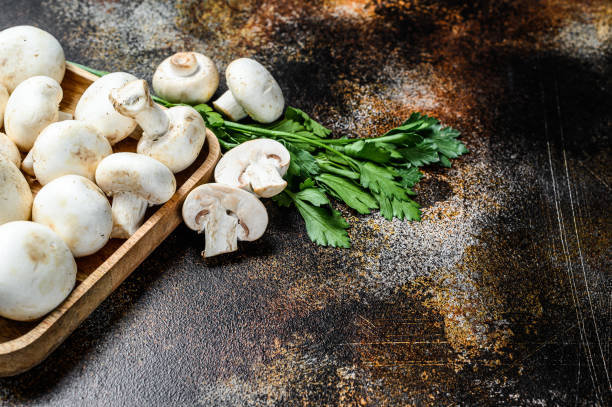 istock mushroom champignon in a bamboo bowl. Dark background. Top view 1251529567