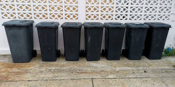 istock Black garbage cans are standing in a row 1251530086