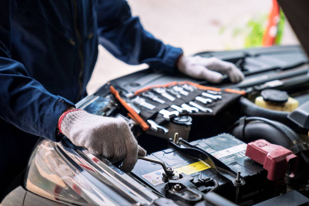 auto mechanic working in the garage, service and maintenance and car maintenance. - car battery imagens e fotografias de stock