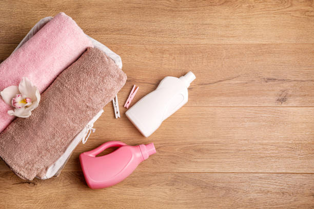 istock Bath towels, detergent and cotton branch on wooden surface 1251531618