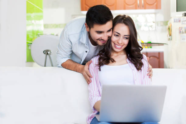 istock Happy young couple looking at laptop's screen at home 1251533744