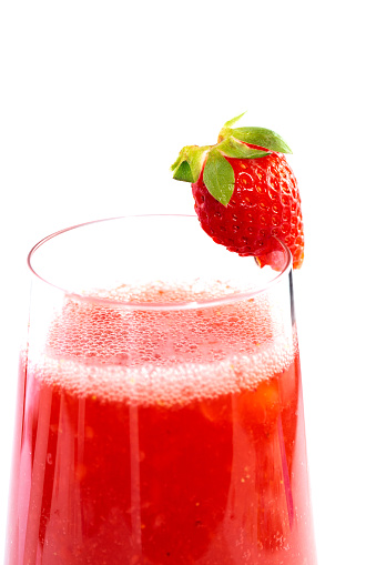 Closeup of a strawberry juice in glass. Studio shot over white background.
