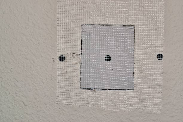 Drywall repairs in wall with fiberglass tape. Drywall repairs in wall, fiberglass tape covering a square repair panel screwed in for support. Copy space on the right side of image. Repair, DIY home maintenance, step by step. painted drywall texture stock pictures, royalty-free photos & images