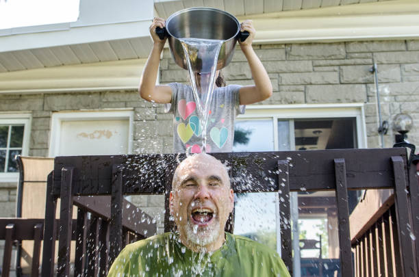 Girl dropping water on father's head