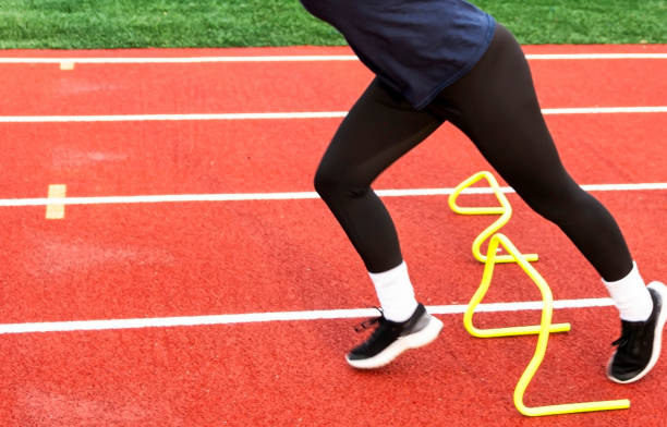 istock Runner running over yellow mini hurdle on a track 1251545270