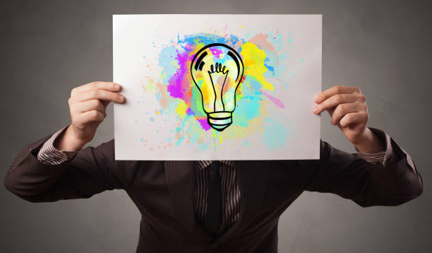 istock Person holding a paper with colorful bulb concept 1251546596