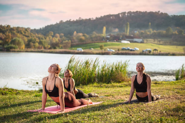 istock Women doing yoga on the lake 1251546749