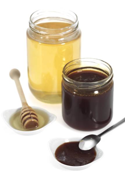istock Molasses and Honey Pots against White Background 1251549278