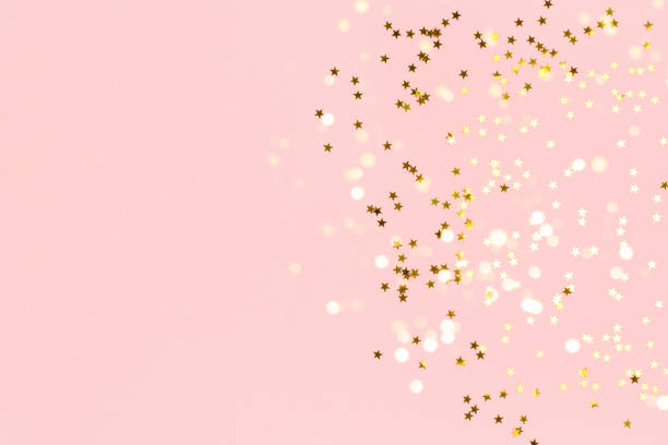 istock Gold stars confetti scattered on a pink pastel background. 1251550131