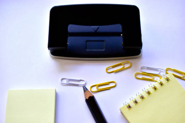 Black large pencil Notepad paper clips and black office hole punch