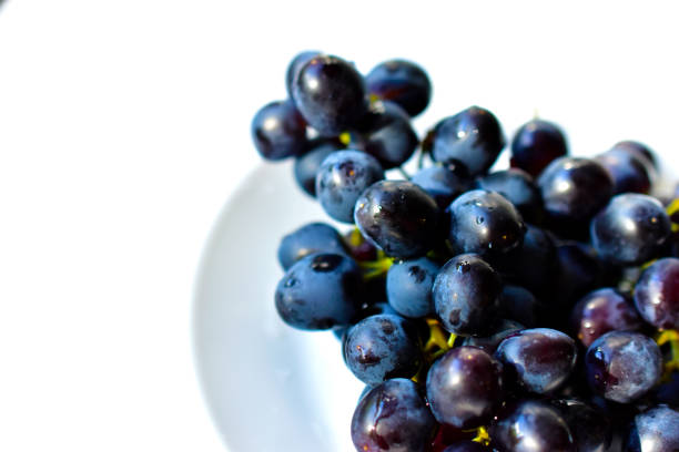 istock Black and delicious grapes on a white plate 1251551735