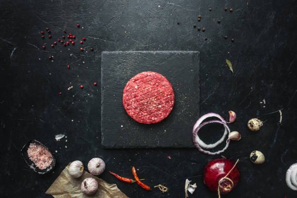 istock Raw minced beef burgers with spices layout 1251552503