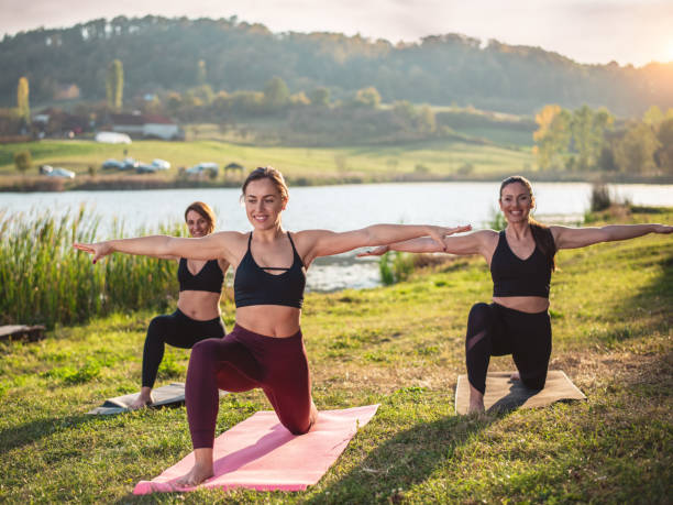 istock Women doing yoga on the lake 1251553986