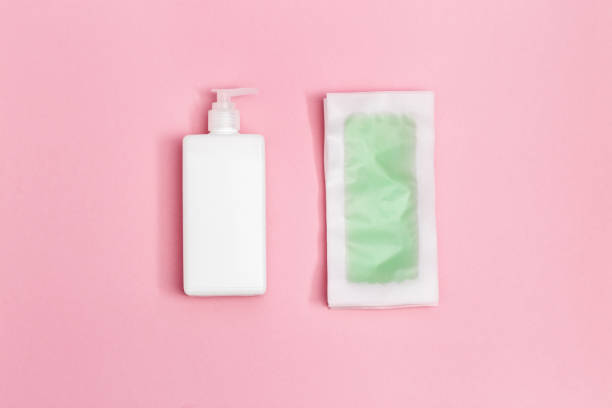 istock Green waxing strips with mint and cooling effect, body moisturizer on pink paper background with copy space. Flat lay. 1251554939