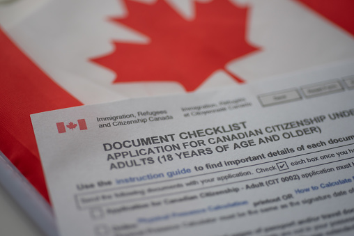 Solicitud de lista de verificación de documentos para la ciudadanía canadiense junto a la bandera canadiense, vista de cerca. photo