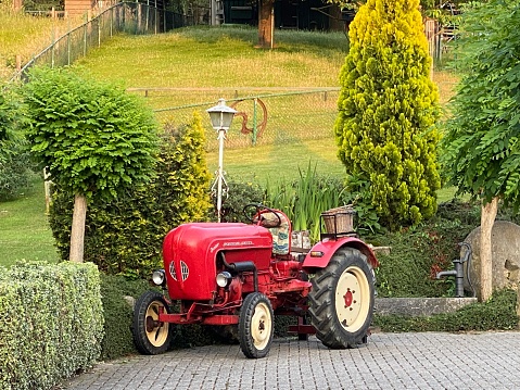 Brunssum, the Netherlands, - June 22, 2020. Vintage tractor parked in a Summer garden.