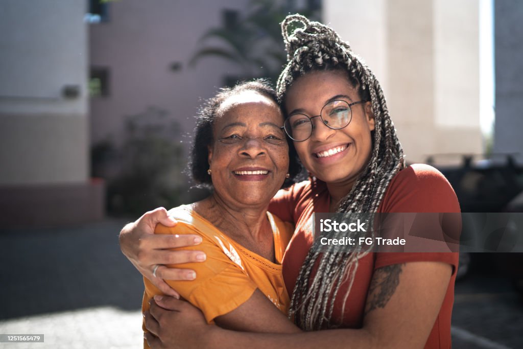 Portrait of grandmother and granddaughter embracing outside Family Stock Photo