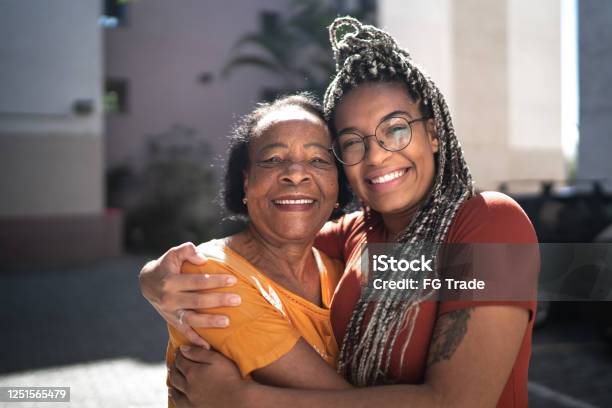 Portrait Of Grandmother And Granddaughter Embracing Outside Stock Photo - Download Image Now