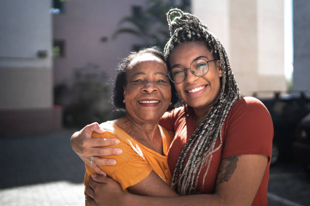 portrait of grandmother and granddaughter embracing outside - family portrait imagens e fotografias de stock