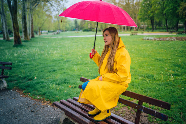 istock Woman with red umbrella outdoors in the rain 1251565720