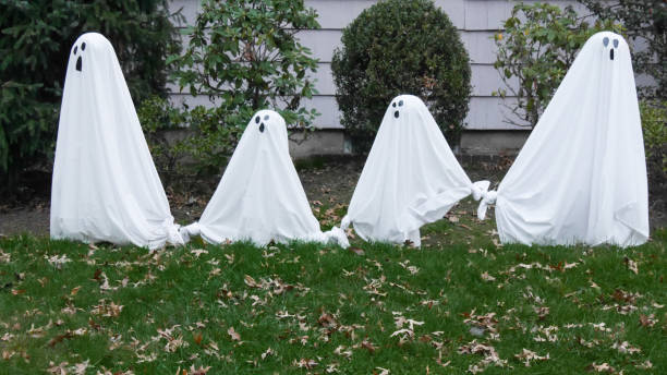 istock Four ghosts on a lawn during Halloween. 1251567181