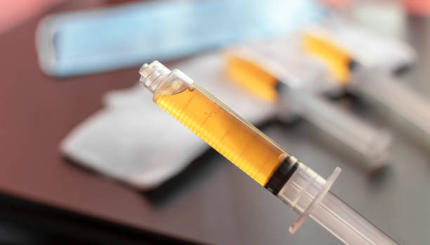 Blood plasma in a syringe on a blurred background. Blood plasma as a solution for the treatment of coronavirus. Blood plasma in a syringe on a blurred background. Blood plasma as a solution for the treatment of coronavirus. Platelet-rich plasma preparation for plasmolifting therapy. Selective focus. blood plasma stock pictures, royalty-free photos & images