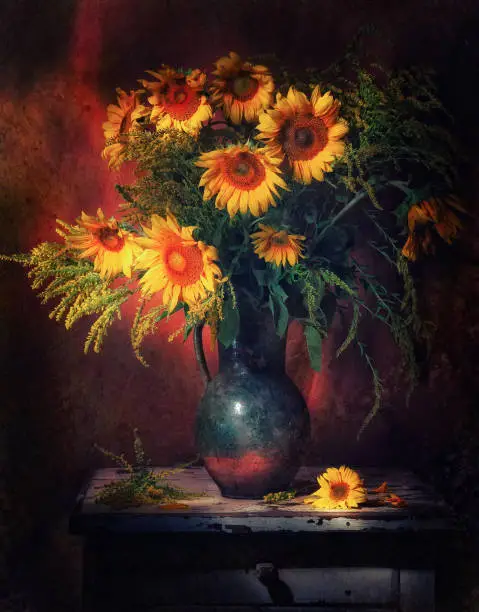 Photo of Classic still life with bouquet of beautiful yellow sunflowers in old vintage jug in a ray of light on brown background . Art photography.