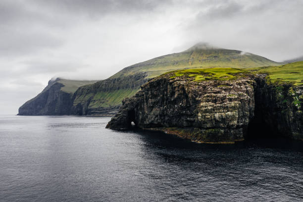 inselklippen über dem meeresrand. atmosphärisches panorama der färöer. - cliff at the edge of grass sea stock-fotos und bilder