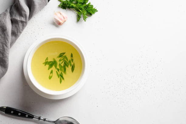 istock Chicken broth with green onion in white bowl on white table. Copy space. Top view. 1251572982