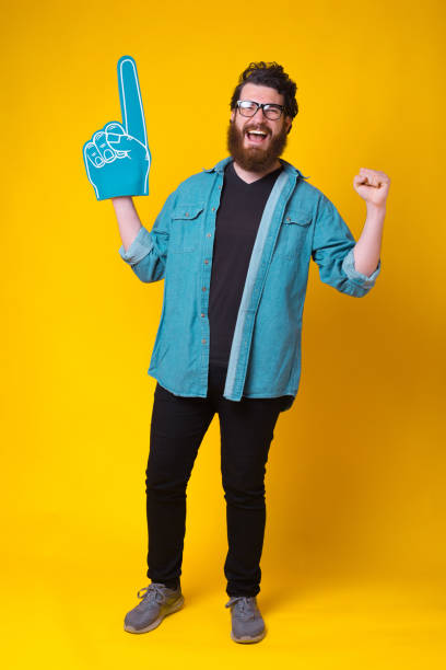 istock Excited bearded man is making the winner gesture while wearing a fan glove 1251573587