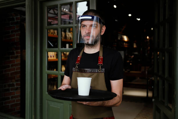 istock Man working in cafe, with face mask 1251573957