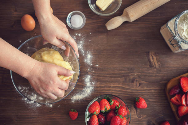 Young woman preparing strawberry galette or open strawberry pie