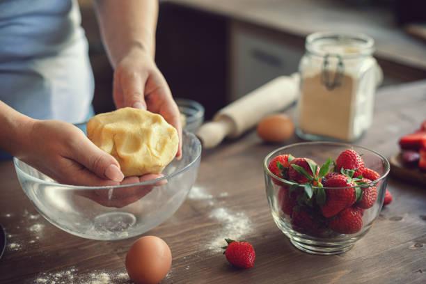 Young woman preparing strawberry galette or open strawberry pie