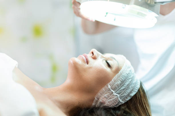 istock Cosmetologist Inspecting Young Woman's Skin Close up. 1251576367