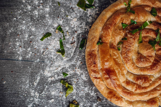 Greek pie Greek pie cover with spinach leaves and flour next to it. filo pastry stock pictures, royalty-free photos & images