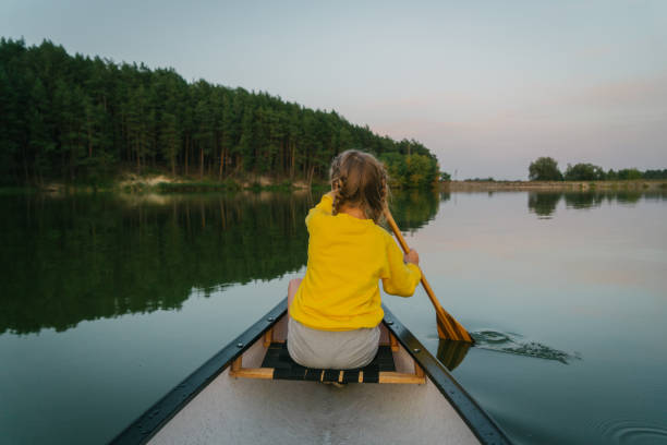 istock Girl canoeing on lake at sunset 1251577426